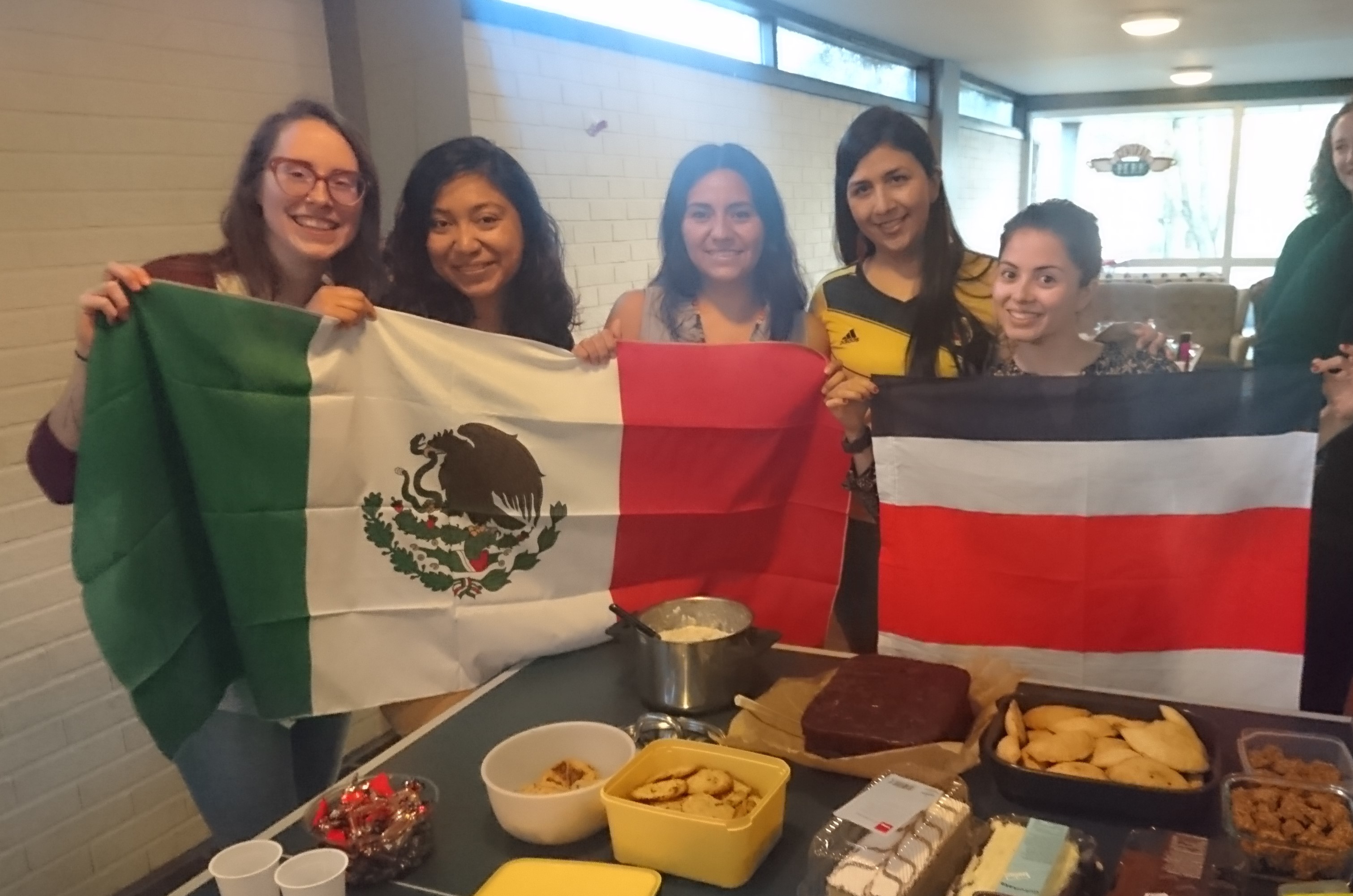 The master chefs for the class dinner, holding flags with food in front of them.