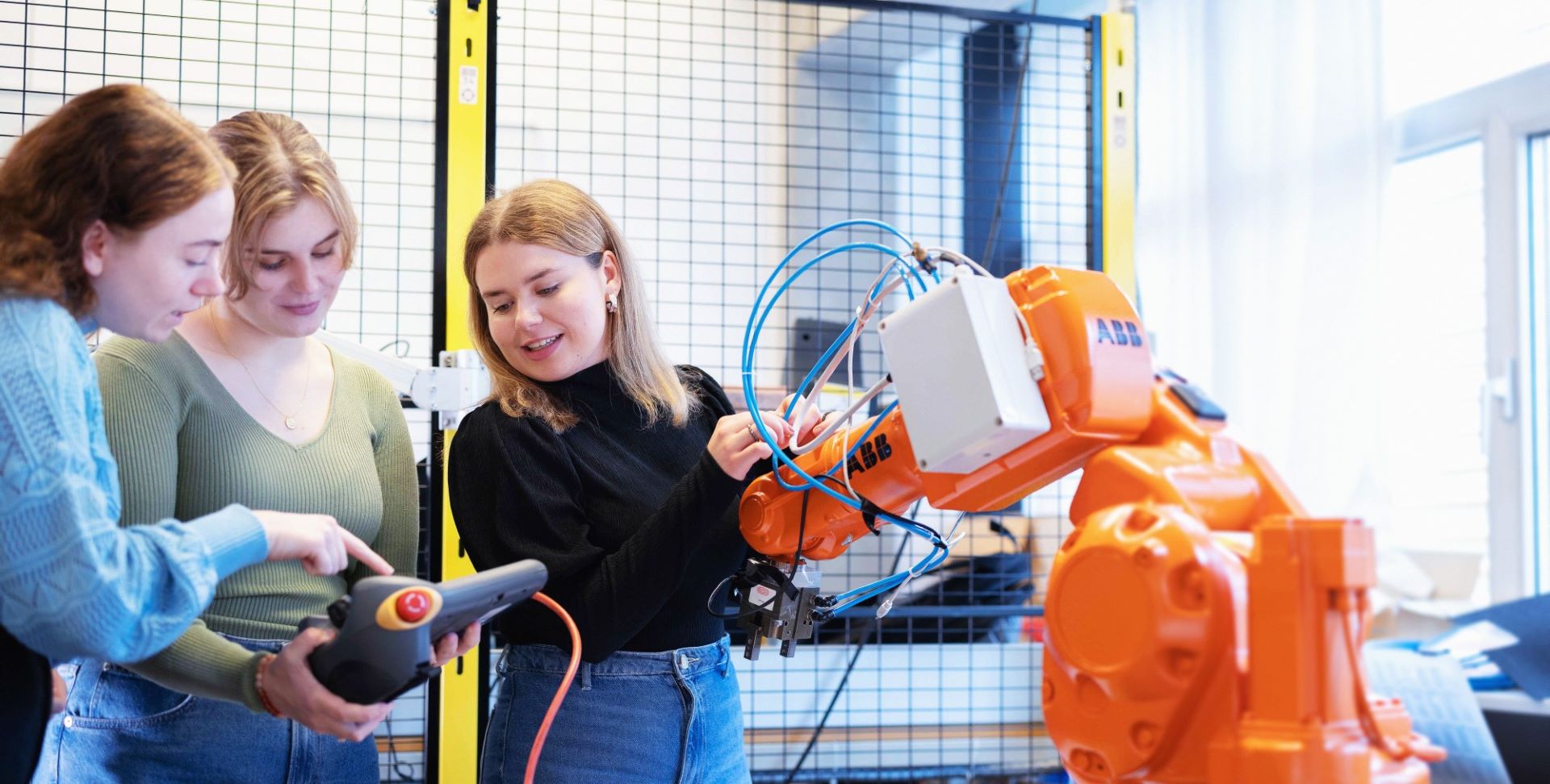 Tre kvinnelige studenter på robotlaben.