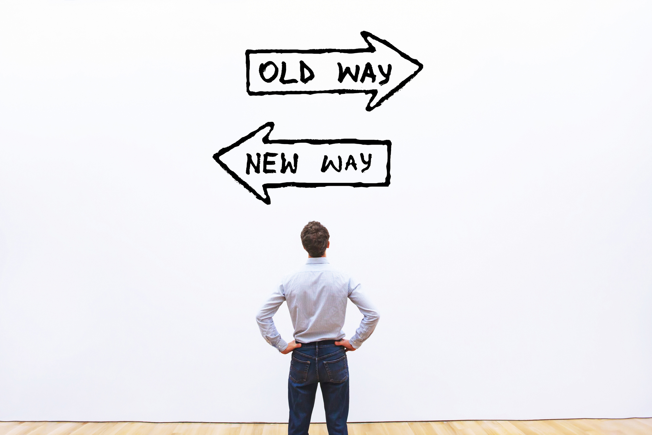 Man standing by a sign pointing "old way " and "new way"