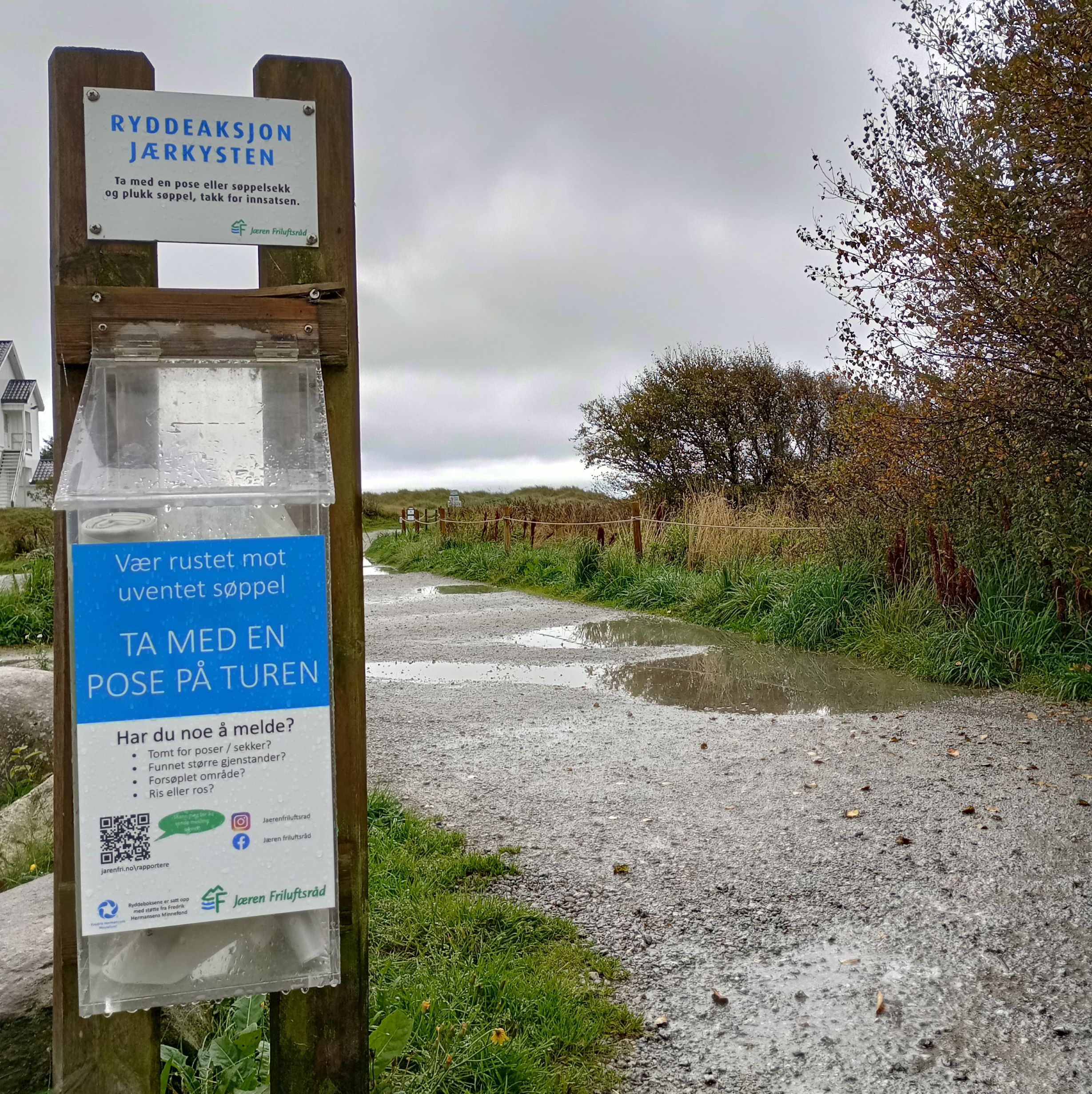 A photograph of a station providing bags to collect trash at the beach