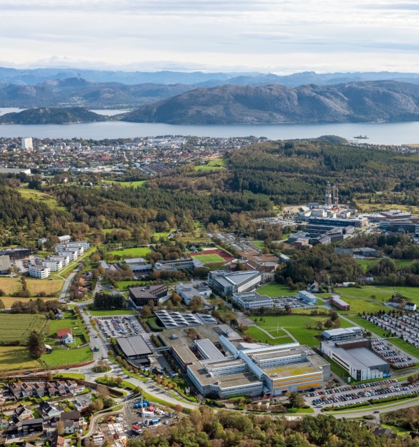 Flyfoto av campusområdet med fjord og fjell i bakgrunnen