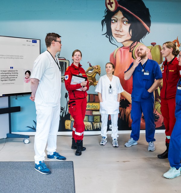 Seks helsearbeidere i hvite, røde og blå uniformer 