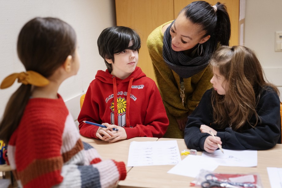 Lærer i samtale med elever i et klasserom. Foto: Marie von Krogh.