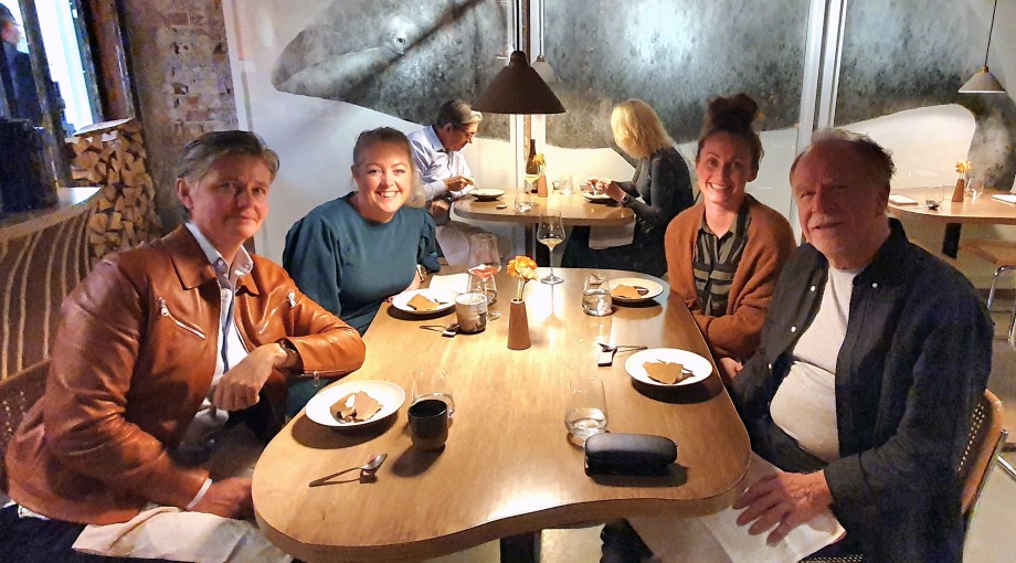 Three women and a man eating at a restaurant.