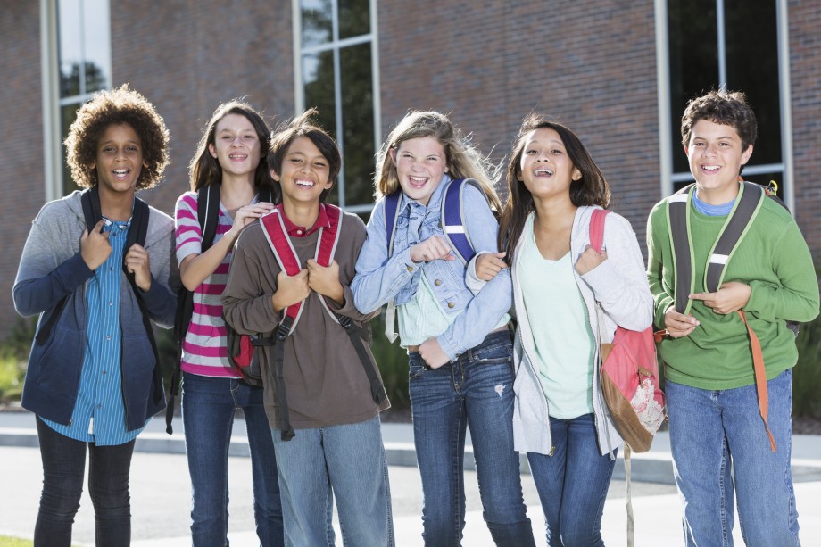 Gruppe med ungdomsskoleelever som smiler. Foto: iStock.